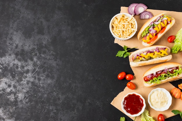 Tasty hotdogs on black slate table