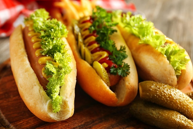 Tasty hotdogs with vegetables on wooden table close up