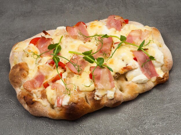 Foto gustosa pizza italiana con pancetta e pollo su sfondo grigio