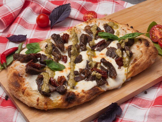 tasty italian pizza with beef mozzarella and pesto