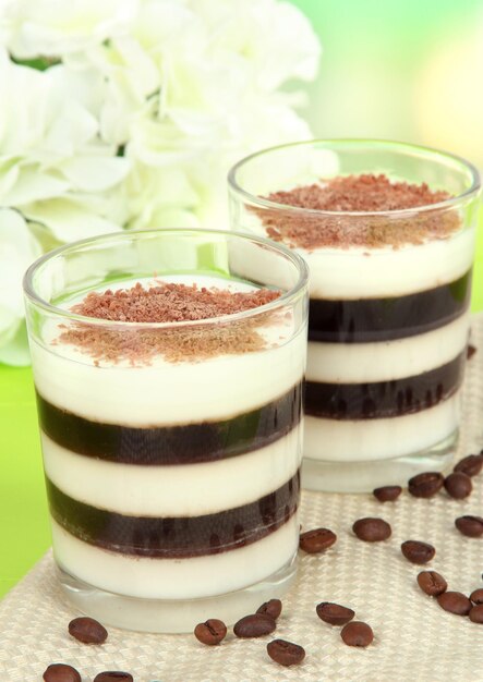 Tasty jelly coffee with milk on table on light background