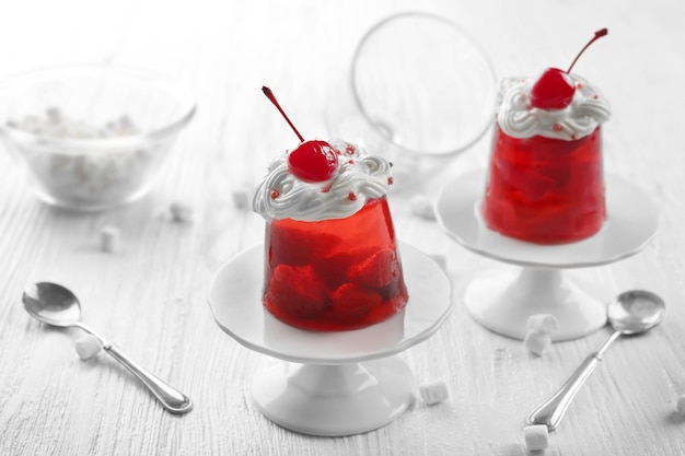 Tasty jelly desserts on white wooden table