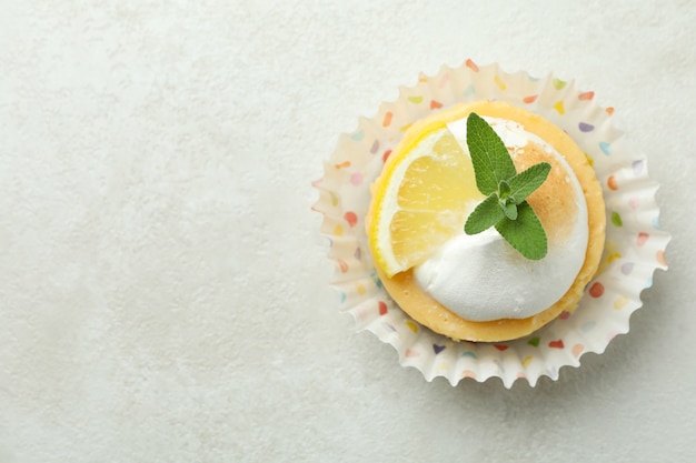 Tasty lemon cupcake on white textured table