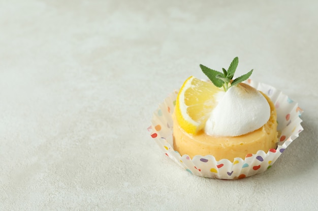 Tasty lemon cupcake on white textured table