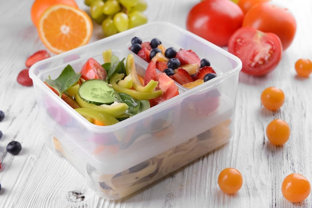 Tasty lunch in plastic containers on wooden table close up