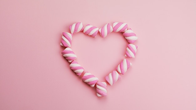 Tasty marshmallows on a pink background