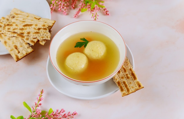 Tasty matzo ball soup with carrot and matzos bread.