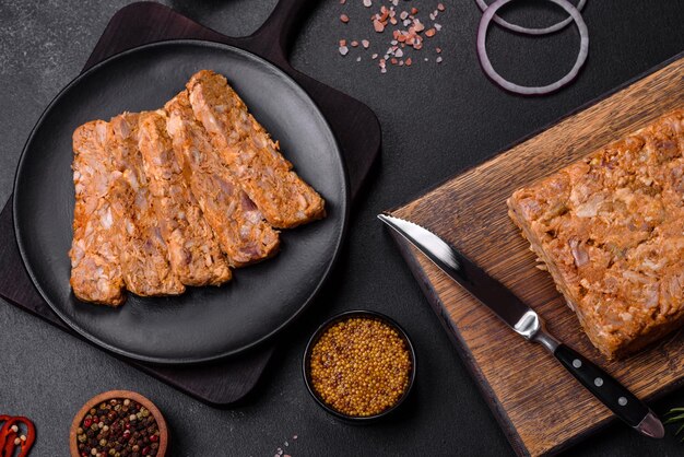 Tasty meat brawn or roll on a wooden cutting board with spices and herbs