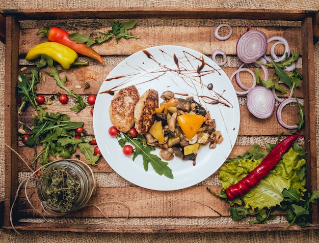 Tasty meat rolls with sour cream and salad on wooden table