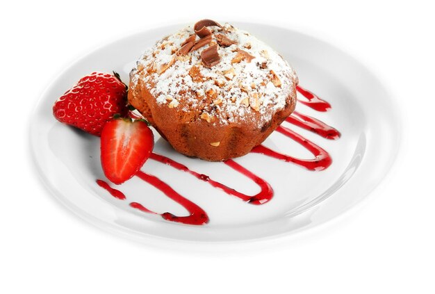 Tasty muffin cake with strawberries and chocolate on plate isolated on white