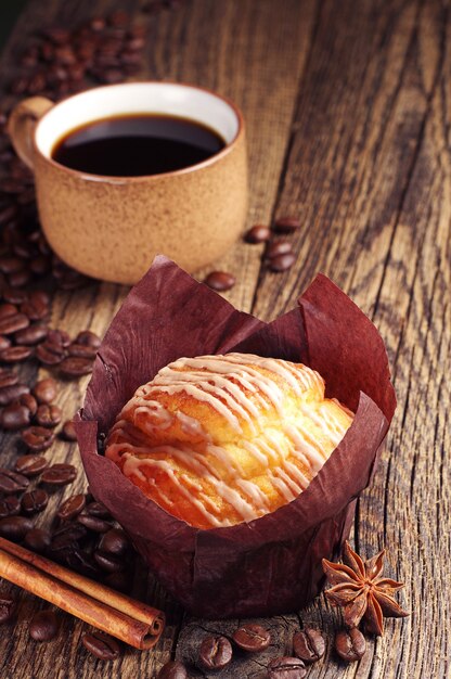 Tasty muffin and coffee cup on vintage wooden table