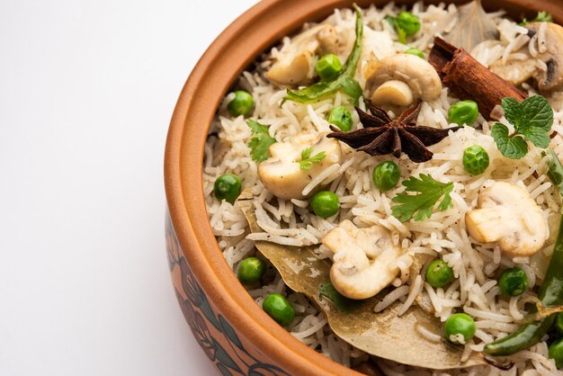 맛있는 버섯 또는 버섯 밥 또는 풀 라브 또는 필라프 또는 풀 라오 또는 비리 야니가 그릇이나 접시에 담겨 선택적으로 제공됩니다.