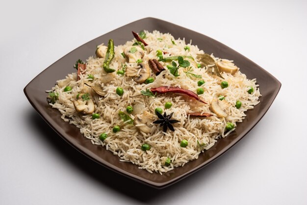 Tasty Mushroom or Mashroom Rice or Pulav or Pilaf or Pulao or Biryani served in a bowl or plate, selective focus