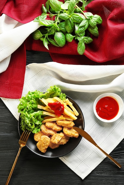 Tasty nuggets french fries and small bowl with sauce for chicken on table