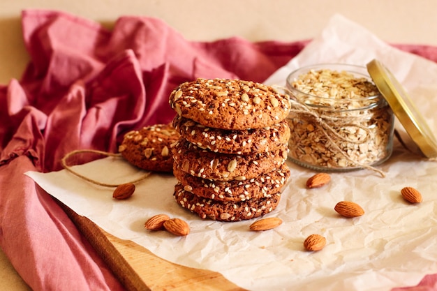 Tasty oatmeal cookies with nuts and seeds on a beige background