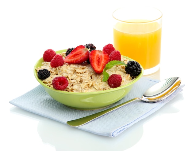 Tasty oatmeal with berries and glass of juice isolated on white