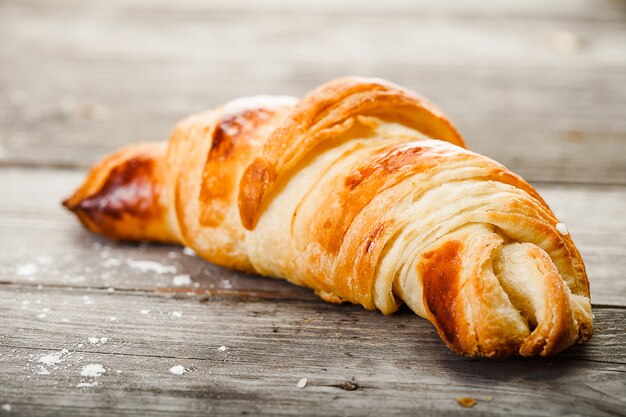 Tasty oil croissant lying on old wooden table