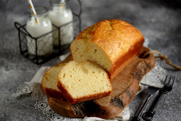 Tasty orange cake with milk on a wooden board. Homemade baking.