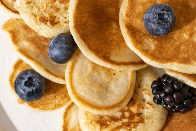 Tasty pancakes and berries on white plate.