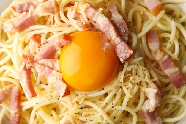 Tasty pasta with bacon and egg, close up