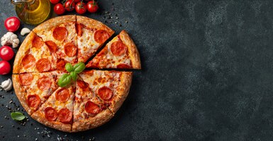 Foto pizza di peperoni saporita su uno sfondo di cemento nero.