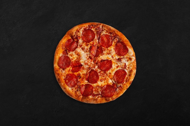 Tasty pepperoni pizza on dark surface.