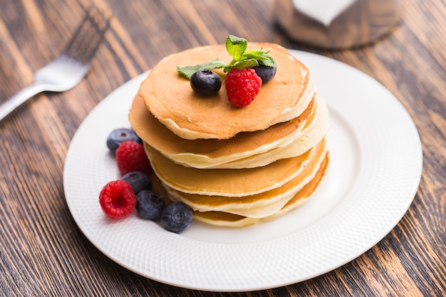 tasty pile of pancakes with blueberries and raspberries