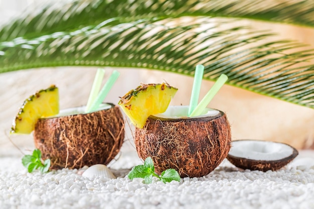 Tasty pinacolada in coconut on sandy beach