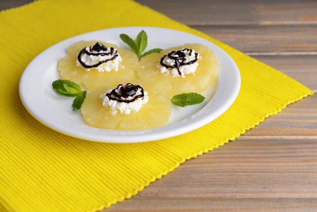 Tasty pineapple with cottage cheese on wooden table