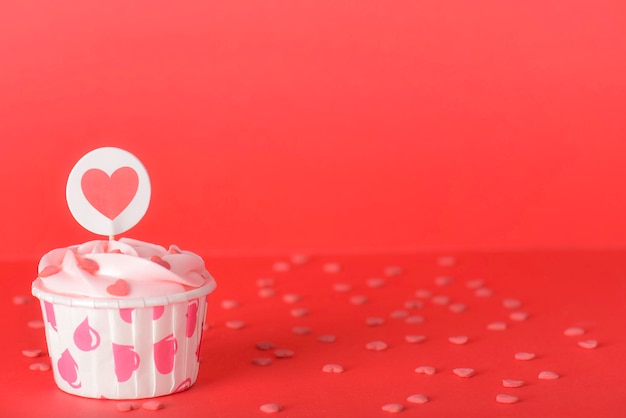 赤の背景においしいピンクパステルバタークリームカップケーキ