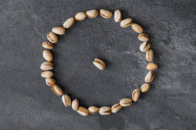 Tasty pistachio nuts on dark background