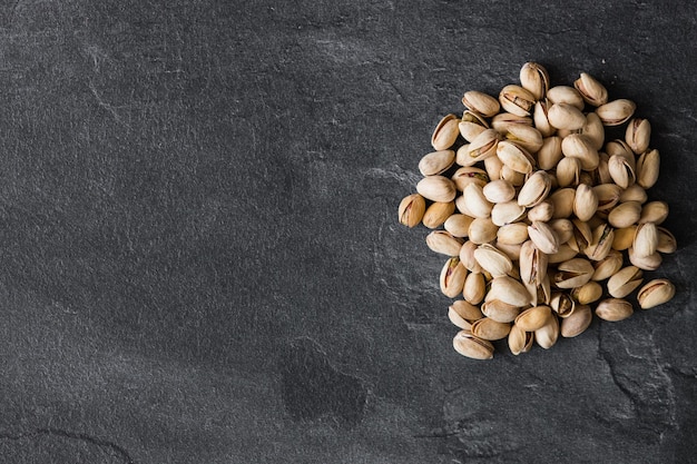 Tasty pistachio nuts on dark background