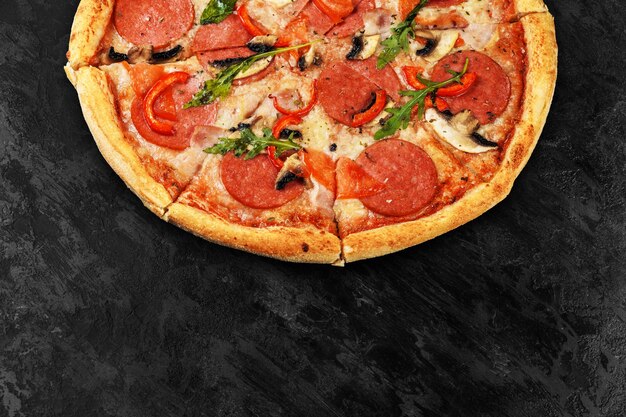 Вкусная пицца на черном бетонном фоне. Вид сверху горячей пиццы с копией пространства для текста.