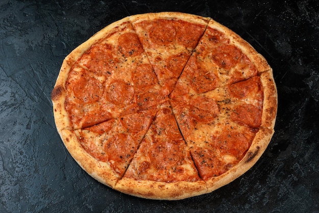 검은 콘크리트 배경에 맛있는 피자 텍스트 플랫 레이 복사 공간이 있는 뜨거운 피자의 상위 뷰