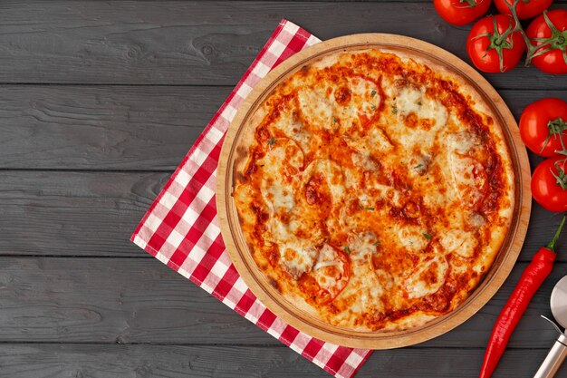 Pizza gustosa su sfondo di legno nero vista dall'alto