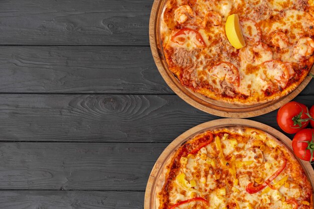 Tasty pizza on black wooden surface top view