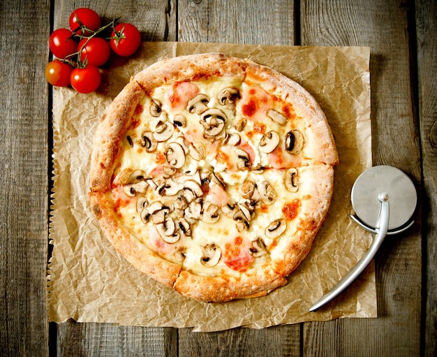 Tasty pizza and knife on an old paper