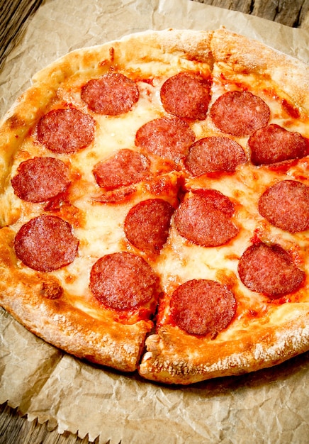 Tasty pizza pepperoni on an old paper