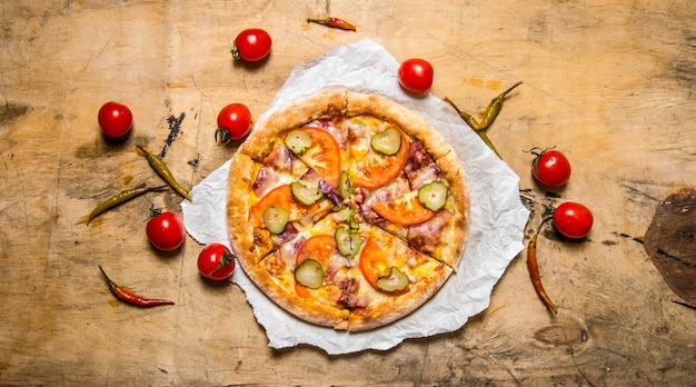 Вкусная пицца с беконом и помидорами. на деревянном столе.