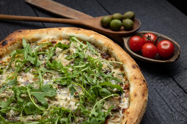 Photo tasty pizza with cheese and vegetables on a wooden dark table