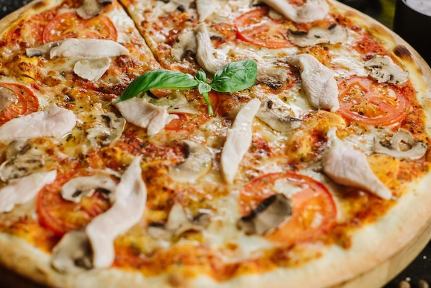 Tasty pizza with chicken meat on black background