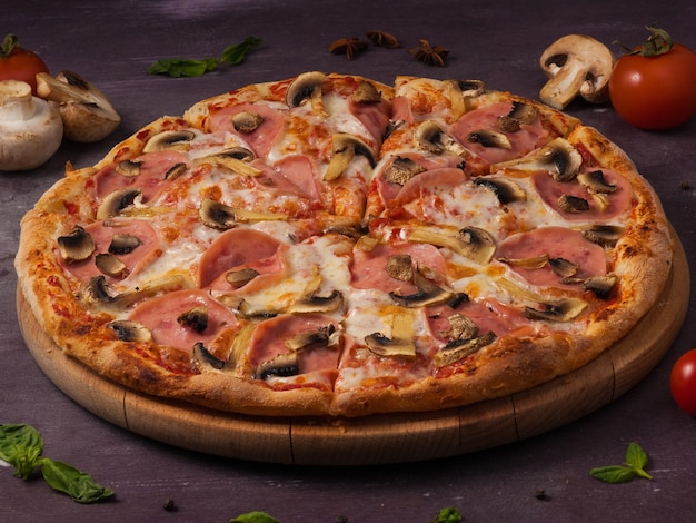 Tasty pizza with ham and mushrooms on a wooden Board