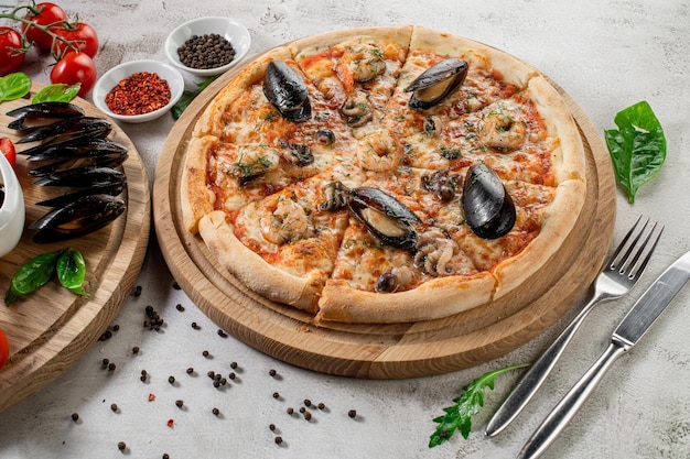 Foto pizza gustosa con calamari e cozze di mare sullo sfondo di cemento