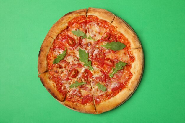 Tasty pizza with tomato on green