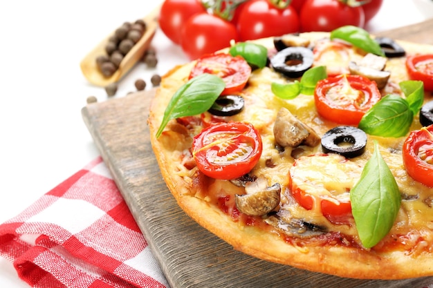 Tasty pizza with vegetables and basil on table close up