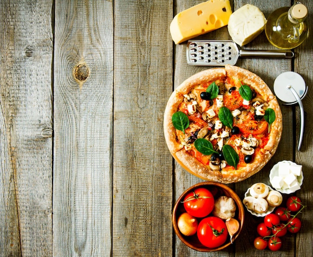 Tasty pizza on a wooden board. Veggie a pizza with ingridients .