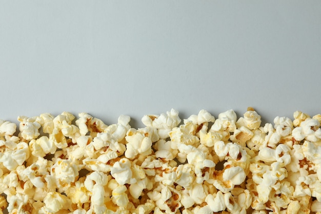 Popcorn gustoso su sfondo grigio chiaro, spazio per il testo.