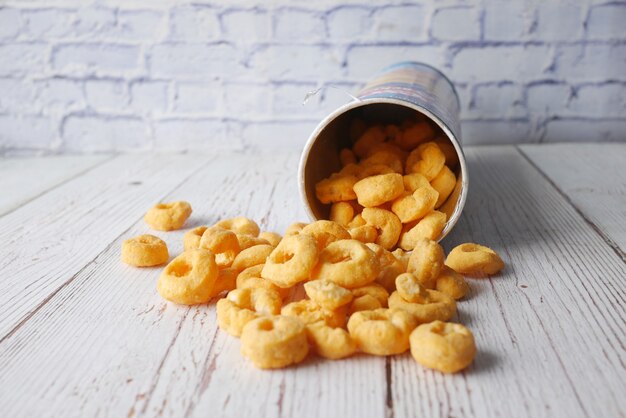 Tasty potato chips spilling from a container