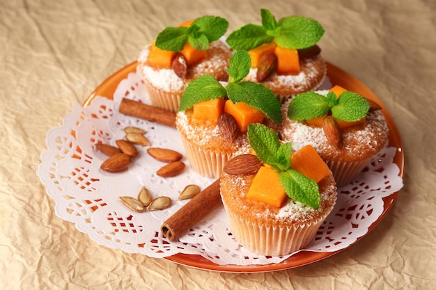 Tasty pumpkin muffins on brown paper