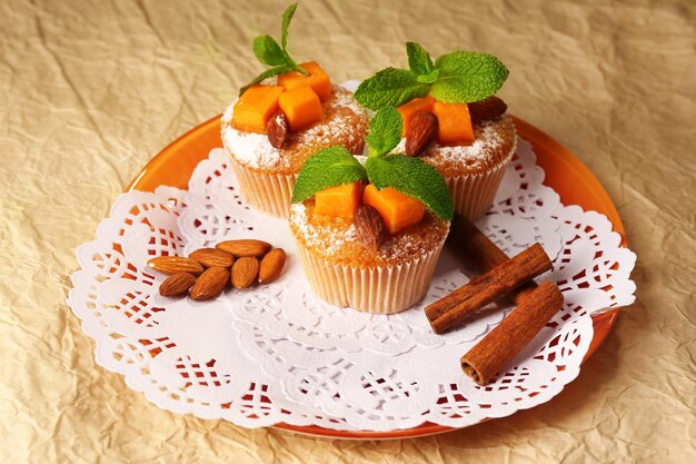 Tasty pumpkin muffins on brown paper